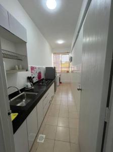 eine Küche mit einer Spüle und einer Arbeitsplatte in der Unterkunft OrchidVilla Homestay at Southville Apartment in Kampong Parit