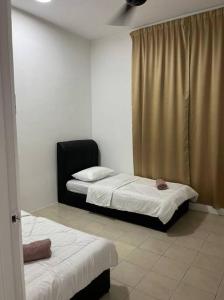 a room with two beds and a window in it at OrchidVilla Homestay at Southville Apartment in Kampong Parit