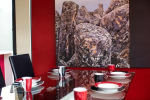 a dining room with a table with a red wall at Corinda Contemporary in Hobart