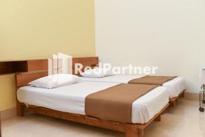 Ένα ή περισσότερα κρεβάτια σε δωμάτιο στο Homestay Rumah Citra Indah Syariah Mitra RedDoorz
