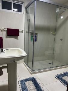 een badkamer met een glazen douche en een wastafel bij Alojamiento El Hogar Casa completa - Prado - Centro Cbba in Cochabamba