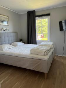 1 dormitorio con 2 camas y ventana en Rämsbyns fritidsby, nära Romme Alpin, en Idkerberget