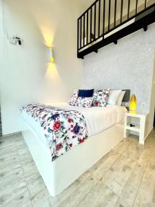 a bedroom with a white bed with red and white pillows at La Vista EcoHouse in Macanal