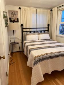 a bedroom with a bed and a lamp and a window at Seaside Beach Front House on the Promenade in Seaside +3 photos