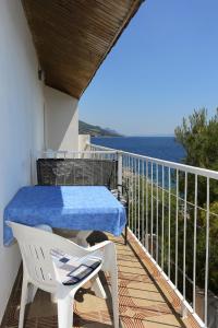 a balcony with a table and a chair and the ocean at Apartments by the sea Dingac - Potocine, Peljesac - 4533 in Potomje