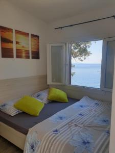 a bedroom with two beds and a large window at Apartments by the sea Dingac - Potocine, Peljesac - 4533 in Potomje