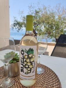 a bottle of wine sitting on a table with two glasses at Apartments by the sea Dingac - Potocine, Peljesac - 4533 in Potomje