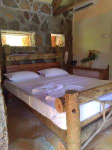 um quarto com uma cama grande num edifício de pedra em La Case Du Pecheur em Grand Sable