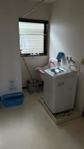 a room with a washing machine and a window at 農家民宿　たなか in Suzu