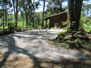 a driveway leading to a cabin in the woods at Cabana Costa Rural in Gramado