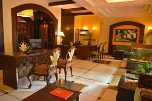 uma sala de estar com cadeiras, uma mesa e um balcão em The Richmond em Pondicherry
