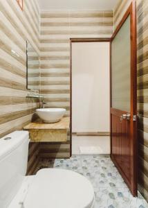 a bathroom with a white toilet and a sink at Ngoc Qui Bungalow in Phu Quoc