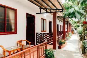 a porch of a house with wooden benches and plants at Ngoc Qui Bungalow in Phu Quoc