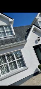 Casa blanca con ventanas y techo en 5 Ardaun Monasteraden County Sligo, en Ballaghaderreen