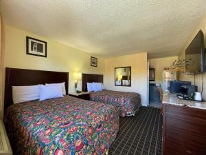 Motel 7 - Near Six Flags, Vallejo - Napa Valley في فاليجو: غرفه فندقيه سريرين وتلفزيون