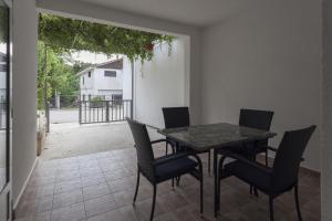 uma sala de jantar com uma mesa e cadeiras num pátio em Apartments with a parking space Zuljana, Peljesac - 4573 em Zuljana