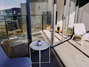Brand New PARK AVENUE Apartment in the Heart of Canberra City في كانبرا: شرفة على طاولة وكراسي في مبنى