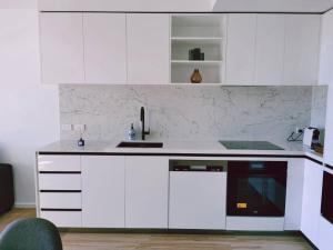 Brand New PARK AVENUE Apartment in the Heart of Canberra City في كانبرا: مطبخ أبيض مع حوض وغسالة صحون