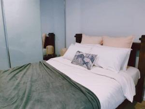 Una cama blanca con dos almohadas encima. en Brand New PARK AVENUE Apartment in the Heart of Canberra City, en Canberra
