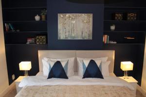 a bedroom with blue walls and a bed with pillows at Alma House by 360Stays - Private Garden, Free Parking, Close to Oxford City Centre with Parking in Oxford