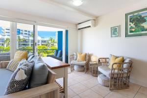 a living room with a couch and chairs at Coral Sea Apartments in Maroochydore