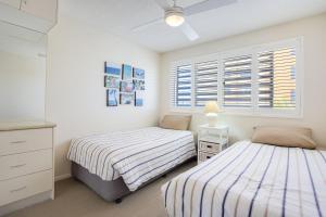 a bedroom with two beds and a window at Coral Sea Apartments in Maroochydore