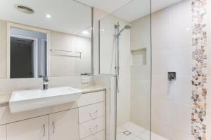 a bathroom with a sink and a shower at Coral Sea Apartments in Maroochydore