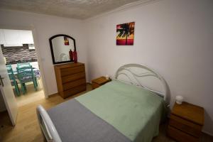 une chambre avec un lit, une commode et un miroir dans l'établissement Rock's Beach Spot A, à Costa da Caparica