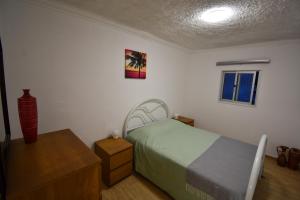 a bedroom with a bed and a table and a window at Rock´s Beach Spot in Costa da Caparica