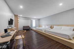 ジョホールバルにあるHako Hotel Taman Uの大きなベッドとデスクが備わるホテルルームです。