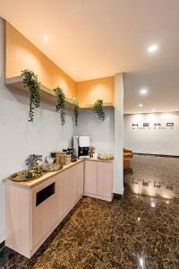 a kitchen with a counter with plants on the wall at Hako Hotel Taman U in Johor Bahru