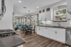 a kitchen with white cabinets and a dining room at The Blue Diamond Retreat in Brenham