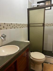 a bathroom with a toilet and a sink at The Royalty Inn ApartmentHotel #1 in Guayaquil
