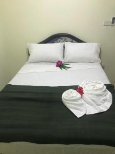 een bed met twee handdoeken bovenop bij ABM Court Apartments in Nadi