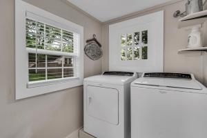 a laundry room with a washer and dryer and two windows at The Blue Diamond Retreat in Brenham