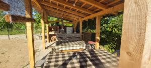 a covered patio with a table and a chair at Kuća za odmor KRNJAIĆ,porodični KAMP in Bosanski Novi