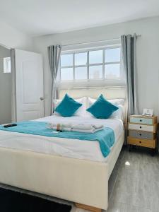 - une chambre avec un grand lit et des oreillers bleus dans l'établissement Le MARIE B&B, à Carthagène des Indes