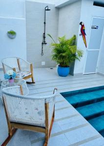 un patio con mesa y sillas junto a una piscina en Le MARIE B&B, en Cartagena de Indias