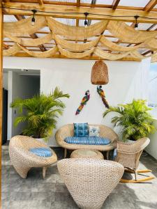a patio with rattan furniture and a wooden ceiling at Le MARIE B&B in Cartagena de Indias