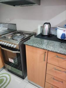a kitchen with a stove and a counter top at Cubao ManhattanHeights Unit 7EF Tower B, 1BR in Manila