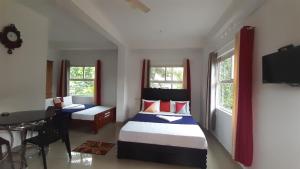 a bedroom with two beds and a table and a desk at Himadri munnar holidays in Munnar