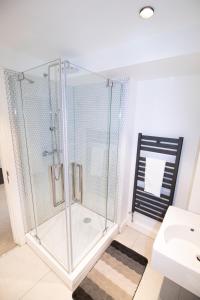a glass shower in a bathroom with a sink at The New52 Oxford by 360Stays - Bespoke 2 Bed Luxury Apartment in the Heart of Oxford City Center with Parking in Oxford