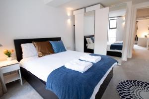 a bedroom with a large bed with towels on it at The New52 Oxford by 360Stays - Bespoke 2 Bed Luxury Apartment in the Heart of Oxford City Center with Parking in Oxford