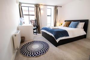 牛津的住宿－The New52 Oxford by 360Stays - Bespoke 2 Bed Luxury Apartment in the Heart of Oxford City Center with Parking，一间卧室配有一张大床,提供蓝白色的毯子