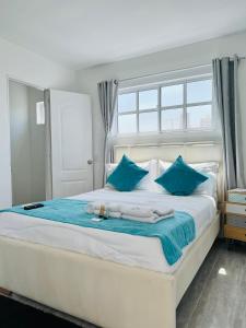 1 dormitorio con 1 cama blanca grande con almohadas azules en Le MARIE B&B, en Cartagena de Indias