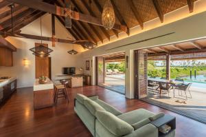 an open living room with a couch and a kitchen and dining room at Six Senses Fiji in Malolo