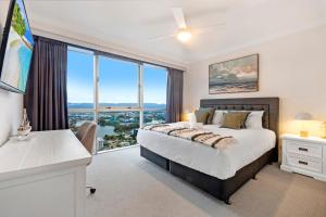 une chambre avec un lit et une grande fenêtre dans l'établissement Skyline North Chevron Renaissance, à Gold Coast