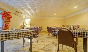 a dining room with tables and chairs and a ceiling at Treebo Trend Vinayak Inn, Near Railway Station in Coimbatore