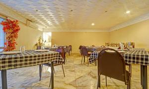 comedor con mesas y sillas y techo en Treebo Trend Vinayak Inn, Near Railway Station, en Coimbatore