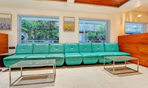 a living room with a blue couch and two windows at Treebo Trend Vinayak Inn, Near Railway Station in Coimbatore